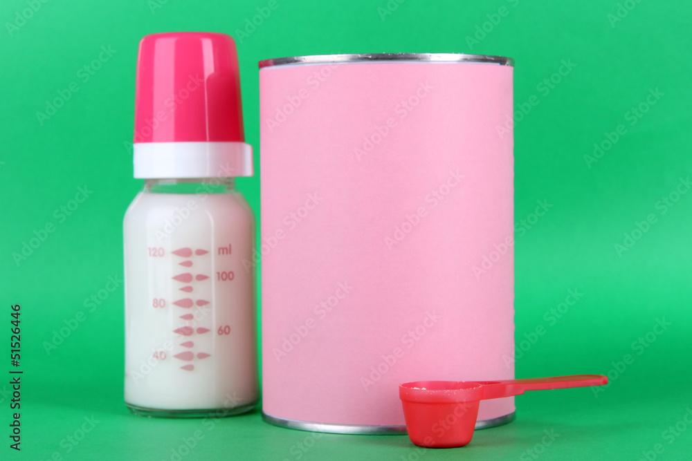 Powdered milk with baby bottle of milk on green background. Powdered milk with baby bottle of milk on green background.