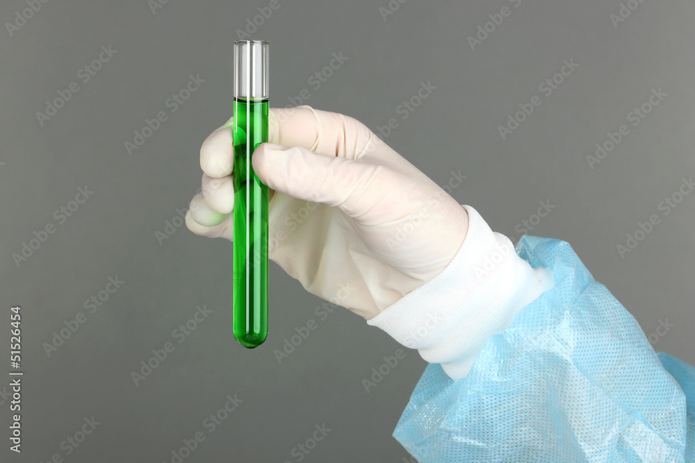 Glass tube with fluid in scientist hand during medical test Glass tube with fluid in scientist hand during medical test