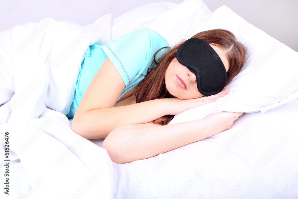 Beautiful young woman sleeping in bed with eye mask Beautiful young woman sleeping in bed with eye mask
