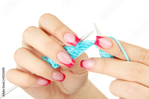 Hands of young woman knitting with blue wool  isolated on white