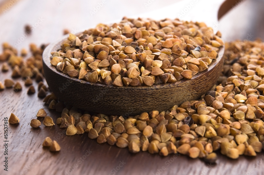 Buckwheat seeds on wooden spoon in closeup Buckwheat seeds on wooden spoon in closeup
