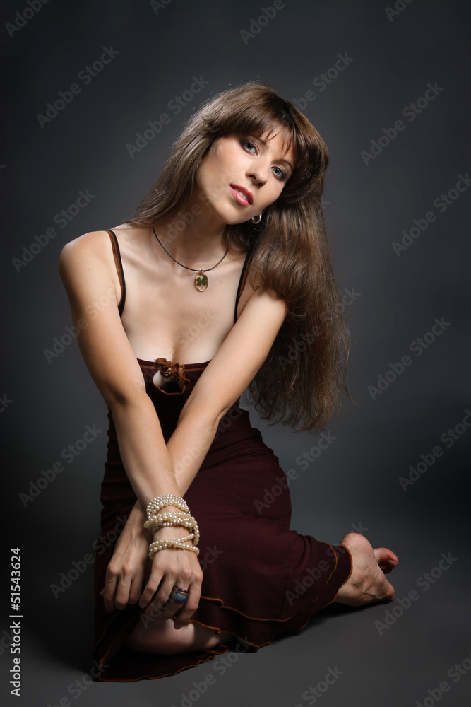 young brunette in a red dress on a gray young brunette in a red dress on a gray