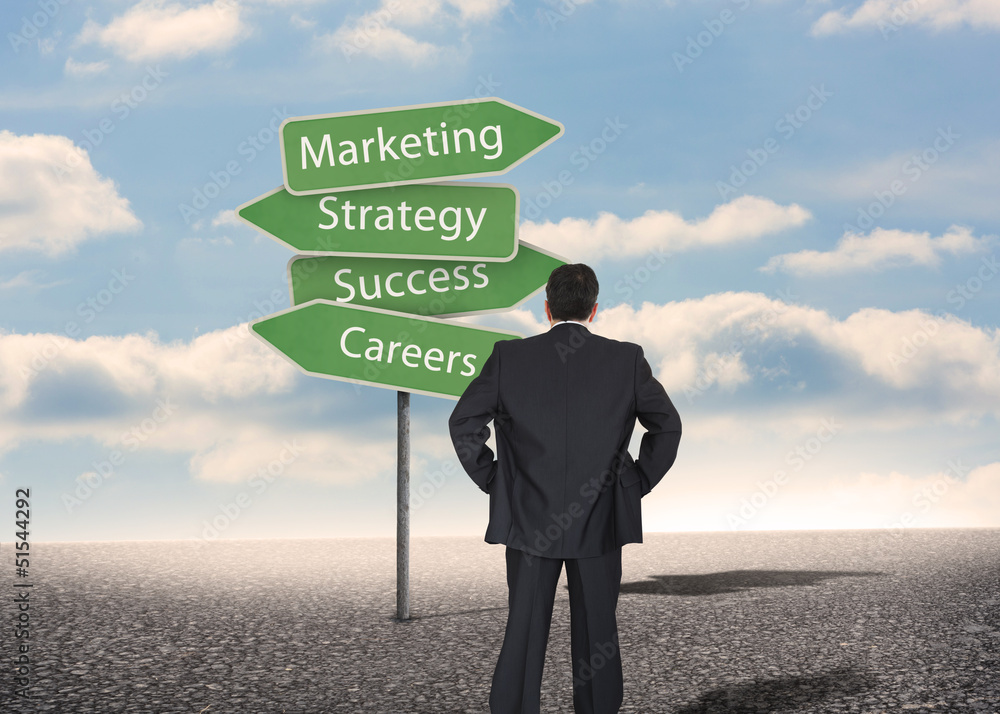 Businessman looking at signposts with marketing terms Businessman looking at signposts with marketing terms