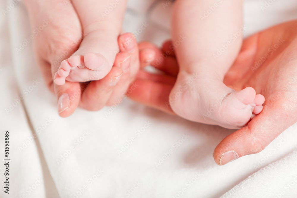 Closeup of baby feet with hands of parents. Studio shot. Closeup of baby feet with hands of parents. Studio shot.