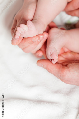 Closeup of baby feet with hands of parents. Studio shot. © ysbrandcosijn
