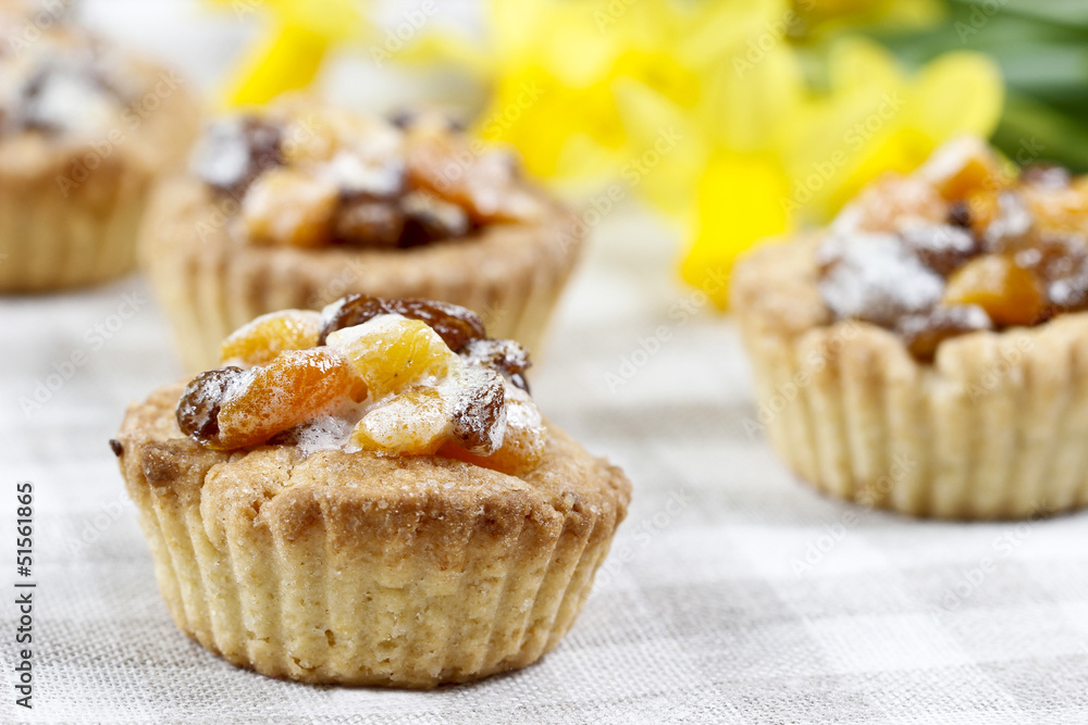 Homemade tarts with dried fruits on checked table cloth Homemade tarts with dried fruits on checked table cloth