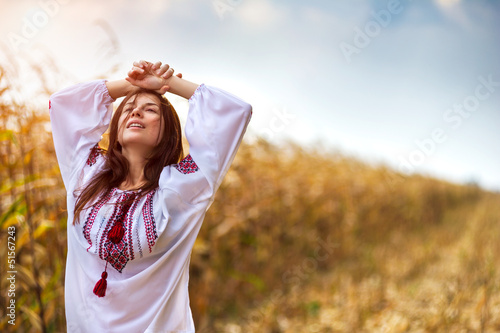 Woman in traditional shirt standing on cornfield