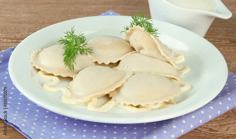 Tasty dumplings on plate, on wooden table