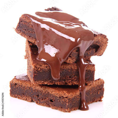 Fotografija Slices of a brownie on white coverd with chocolate
