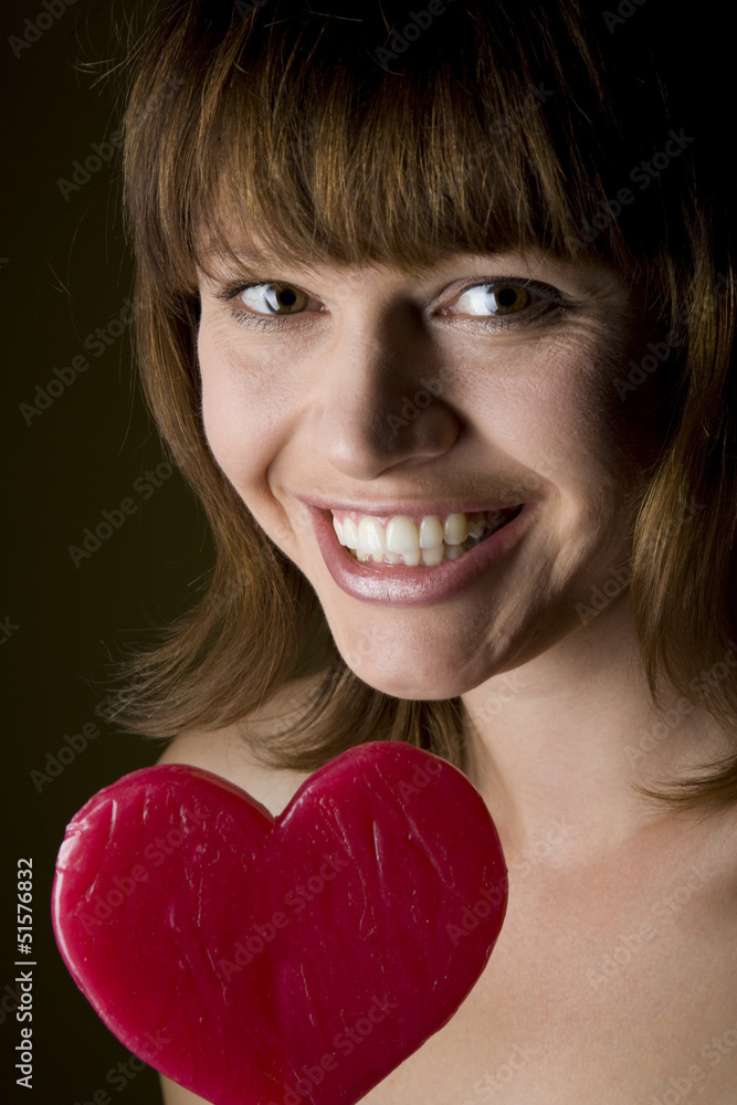Brunette with red heart shaped lollipop Brunette with red heart shaped lollipop