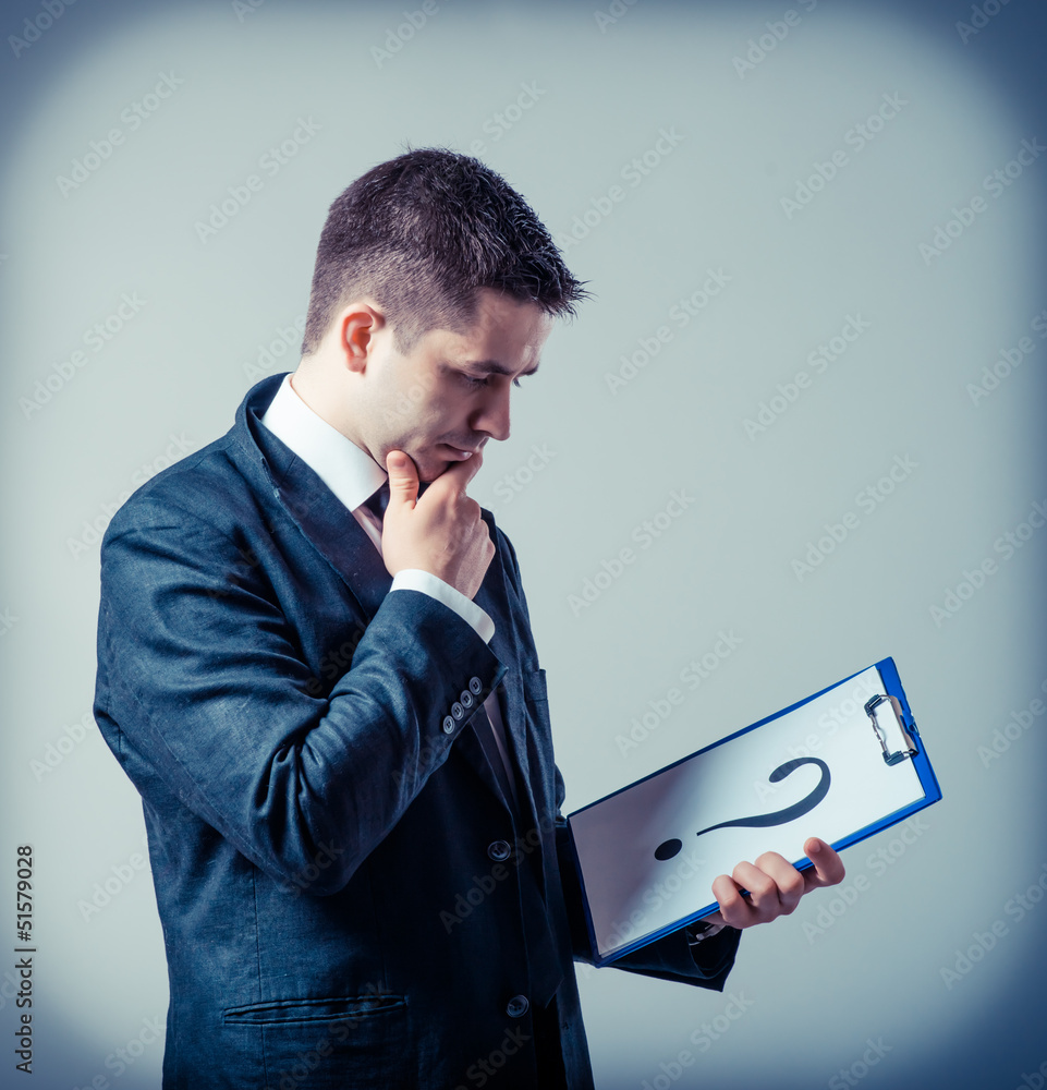 © slasnyi - businessman holding a white billboard with a question mark © slasnyi - businessman holding a white billboard with a question mark