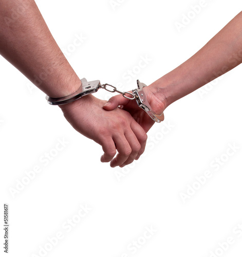 Man and woman holding hands in handcuffs - relationship concept