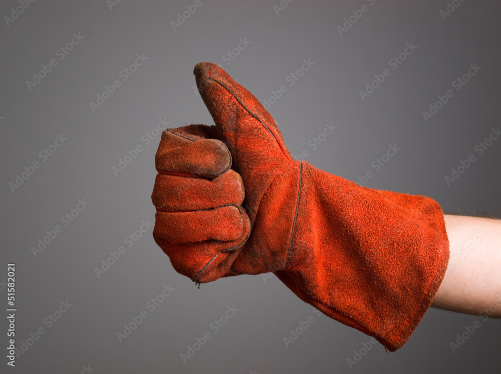 Hand expressing positivity with welder glove - obrazy, fototapety, plakaty 