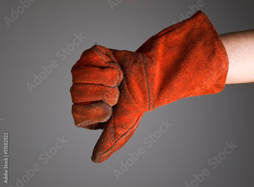 Hand expressing negativity with welder glove