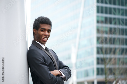 Handsome young african american businessman smiling in the city