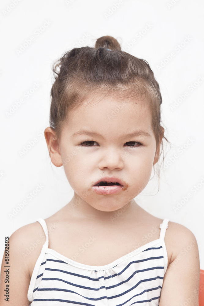 Asian little girl eating chocolate Asian little girl eating chocolate