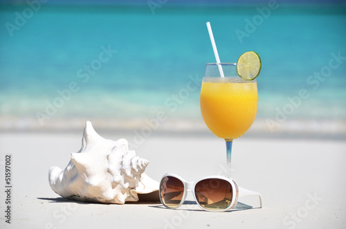 Orange juice, sunglasses and conch on the beach