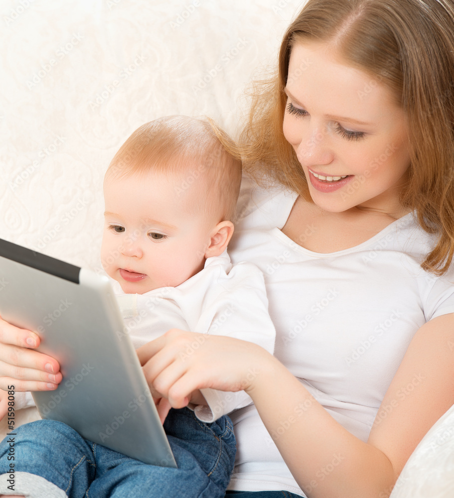 mother and baby with tablet computer on the couch at home mother and baby with tablet computer on the couch at home