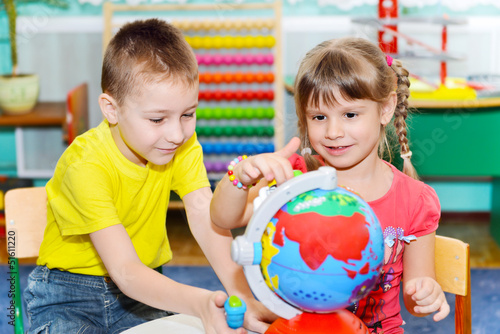 Little children study globe
