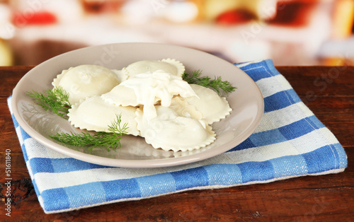 Tasty dumplings on plate, on wooden table