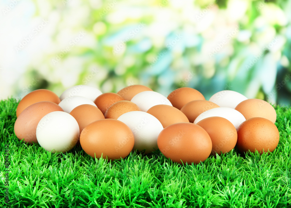 Many eggs on grass on bright background Many eggs on grass on bright background