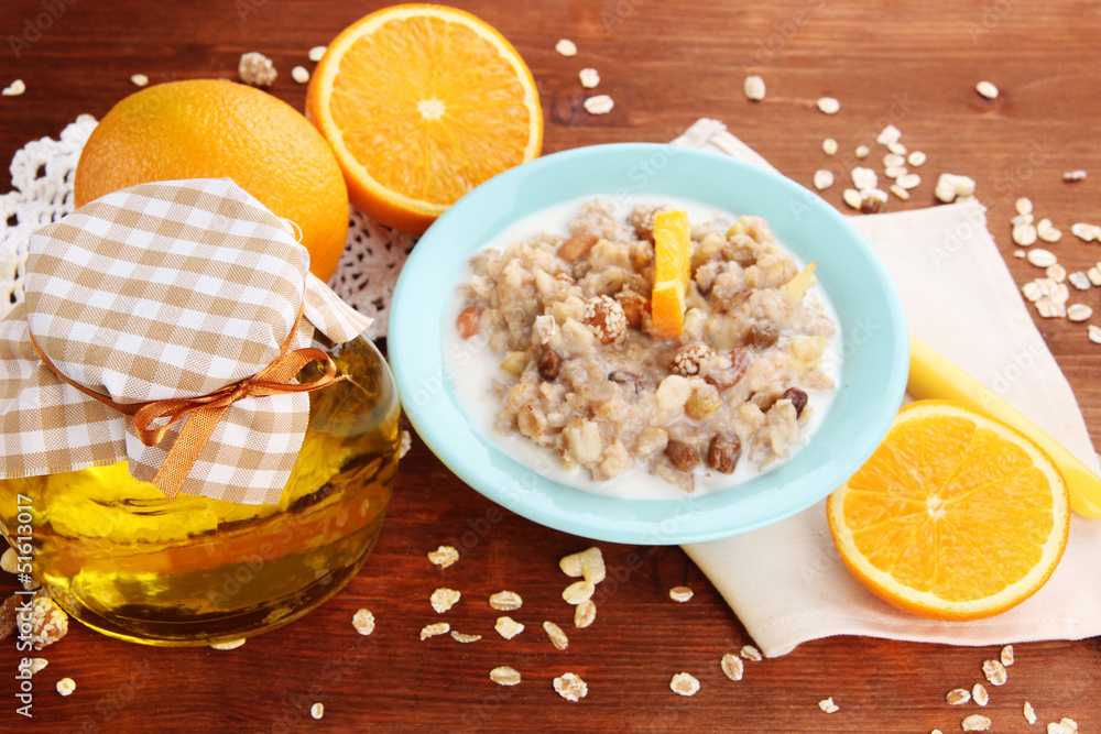 Useful oatmeal in bowl with fruit on wooden table close-up Useful oatmeal in bowl with fruit on wooden table close-up