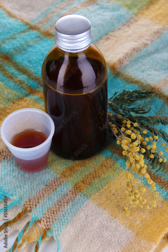 Cough syrup on knitted scarf close-up Cough syrup on knitted scarf close-up