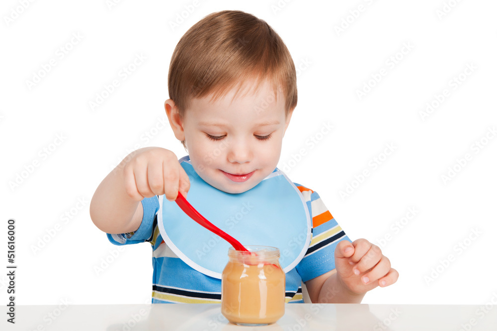Boy eats with a spoon puree