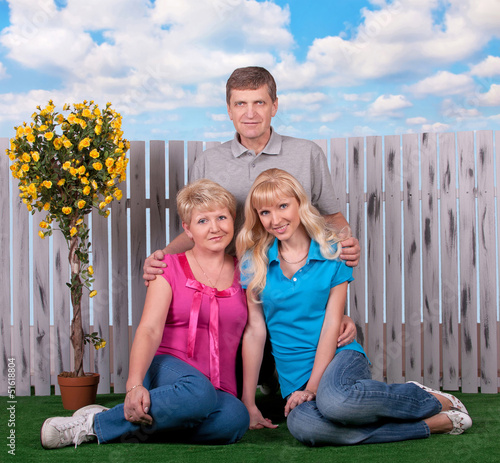 happy family portrait on the green grass in sunner against blue photo