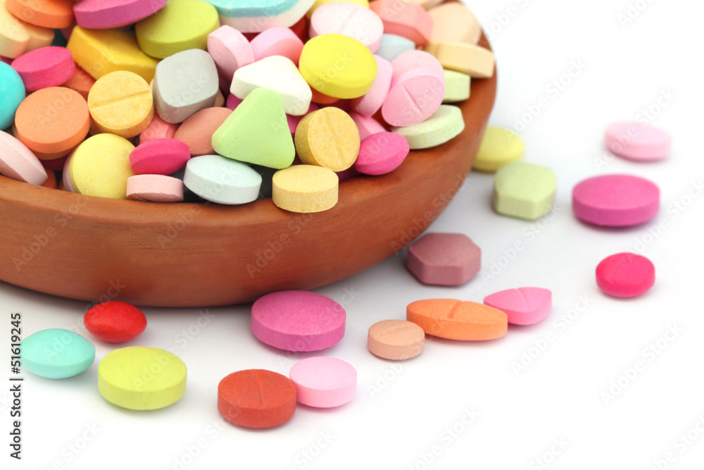 Colorful tablets spilled from a clay pottery Colorful tablets spilled from a clay pottery