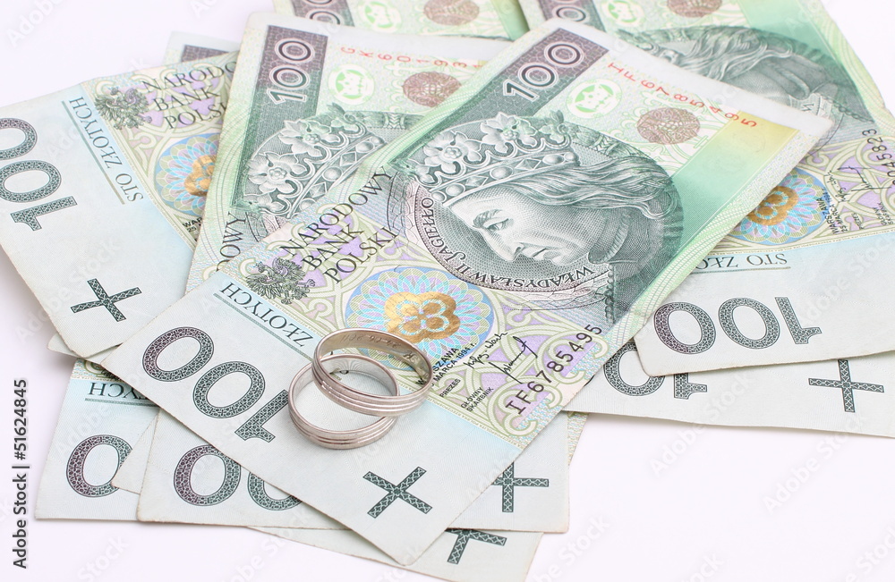 Wedding rings and money on a white background