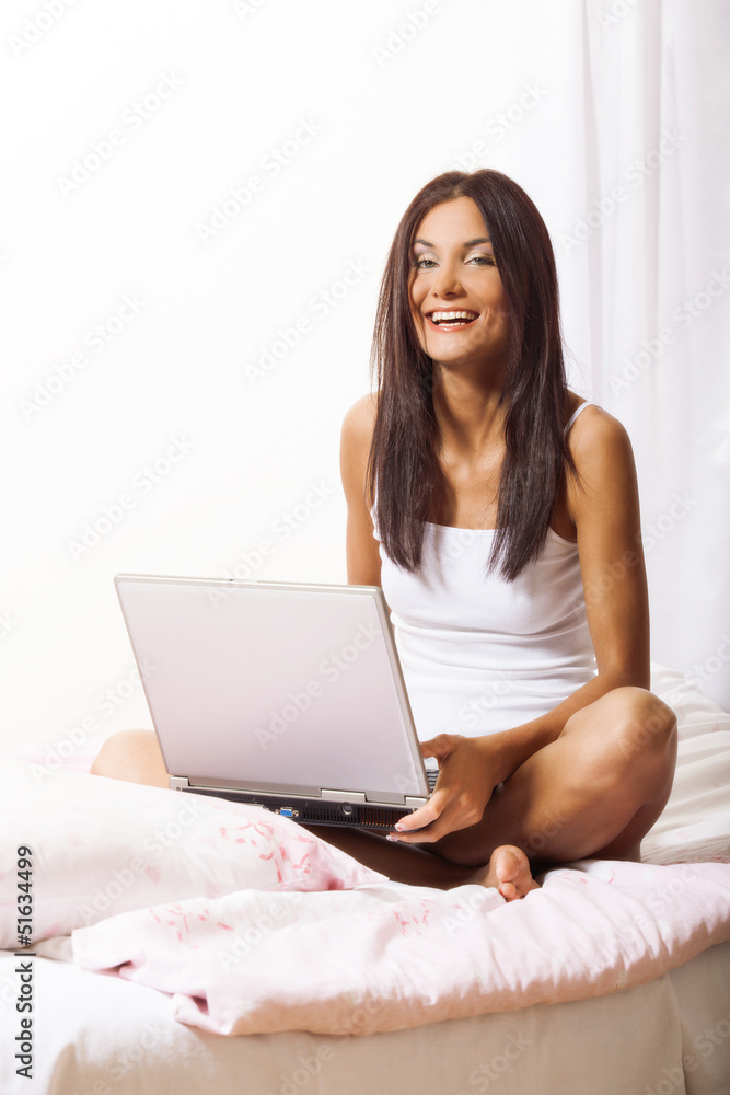 Young woman on bed using laptop Young woman on bed using laptop