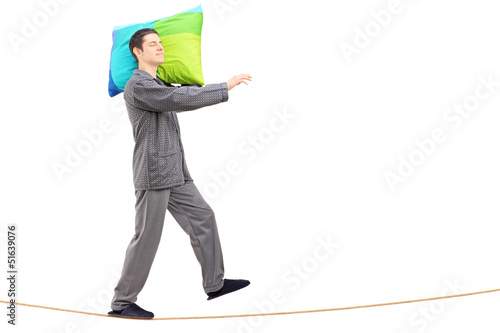 Fotografie Full length portrait of a man sleepwalking on a rope