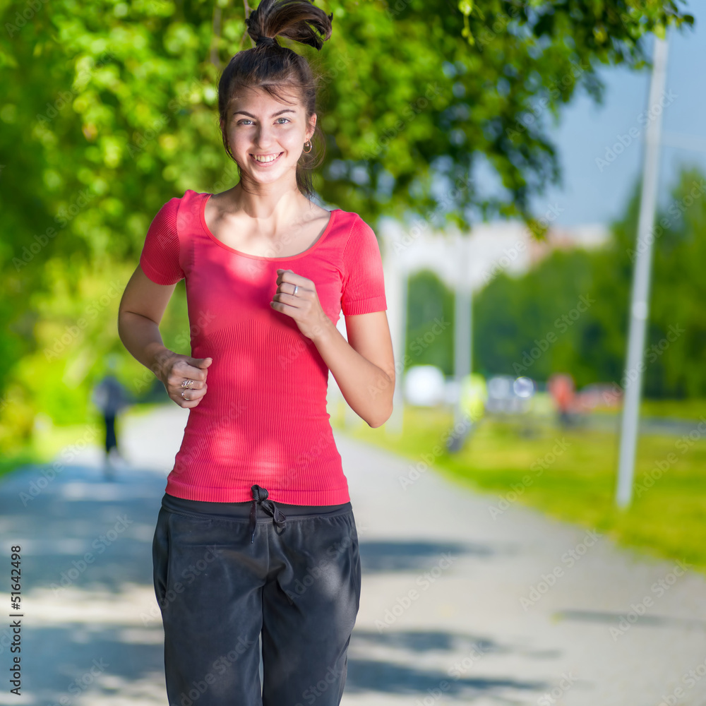 Runner - woman running outdoors in green park Runner - woman running outdoors in green park