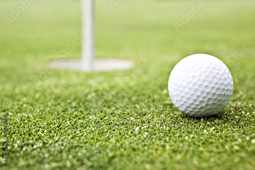 Golf ball on the green close to the hole