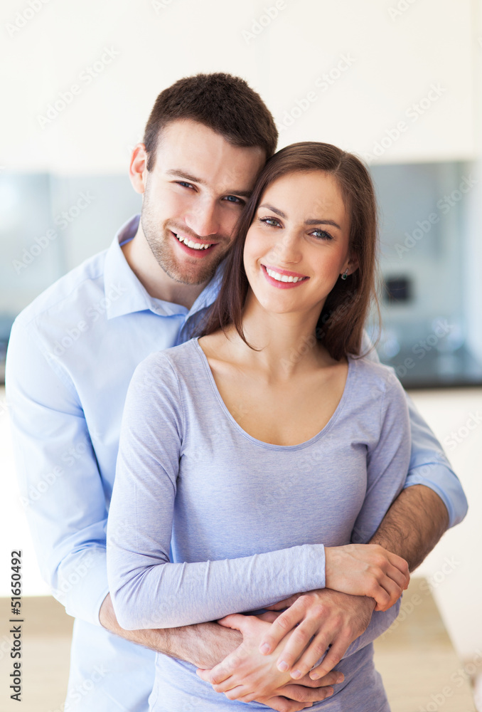 Young couple hugging at home
