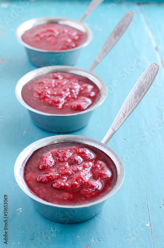 Raspberry sauсe on blue wooden background