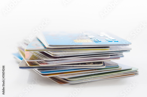 A pile of several colored credit cards on white background 