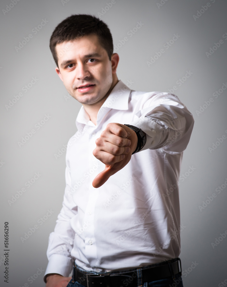 young man showing thumbs down young man showing thumbs down