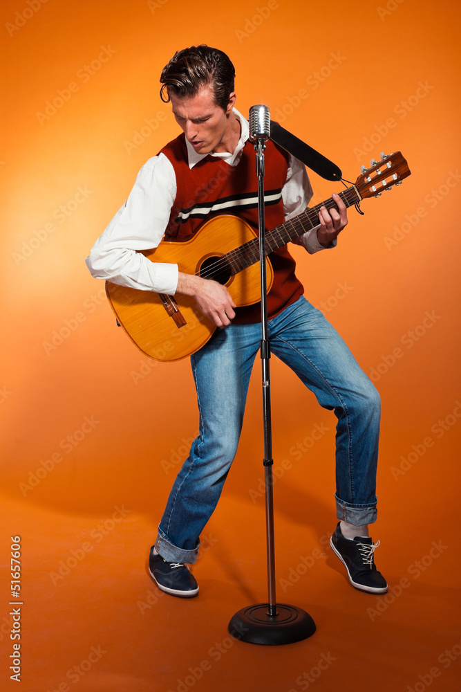 Naklejka premium Retro fifties rock and roll singer playing acoustic guitar.