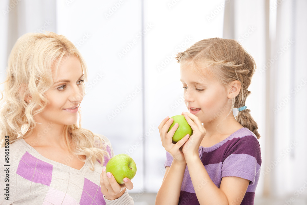 mother and little girl with green apple
