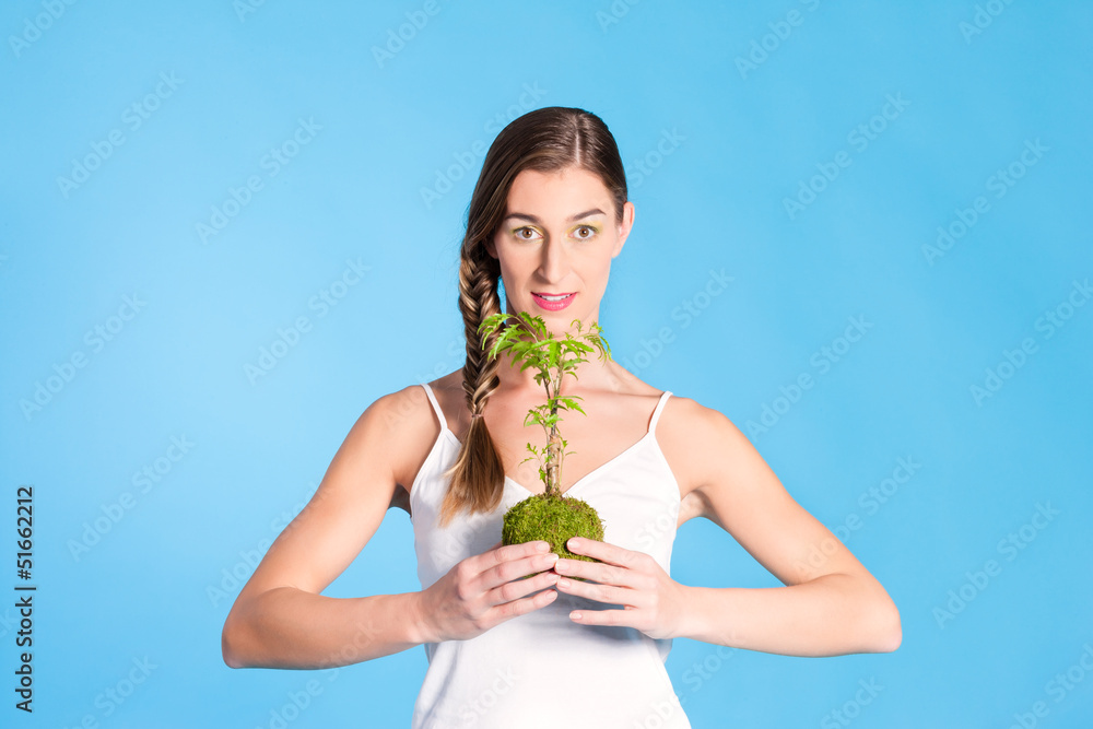 Young Woman holding a small tree Young Woman holding a small tree
