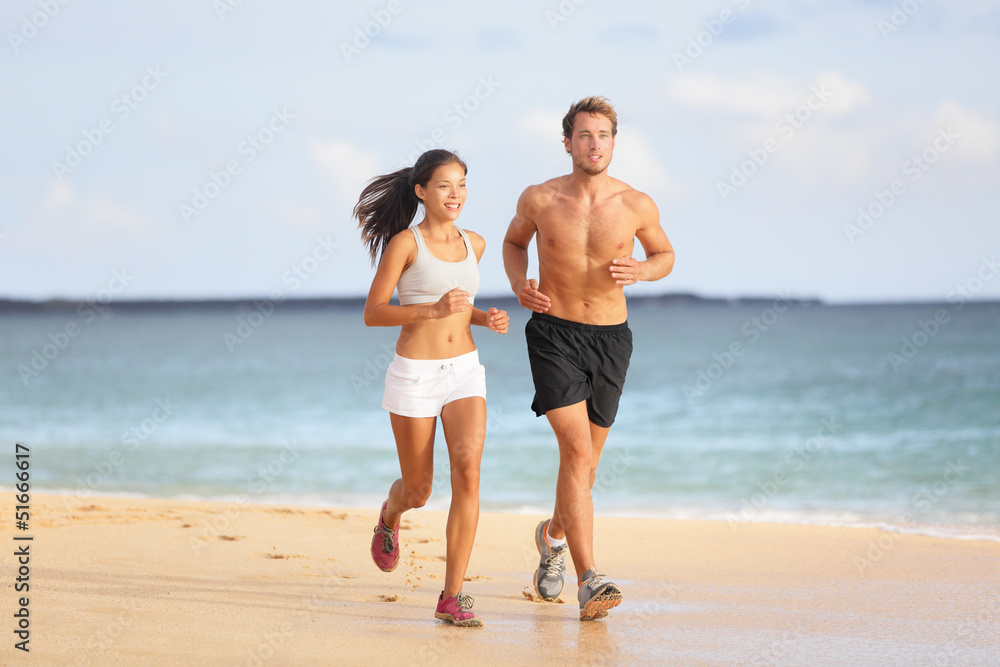 People running - young couple jogging on beach