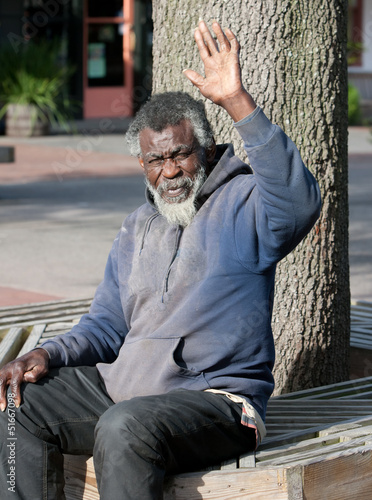 Poor elderly Homeless man waving