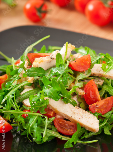grilled fillet of chicken and a salad of arugula and tomato