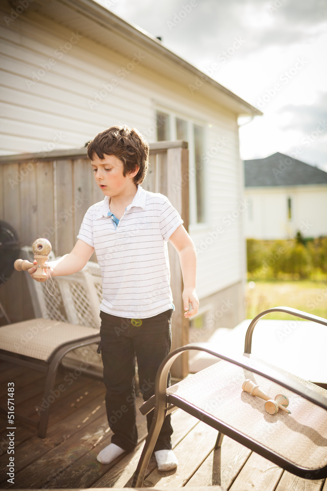 Obraz premium Boy playing cup and ball