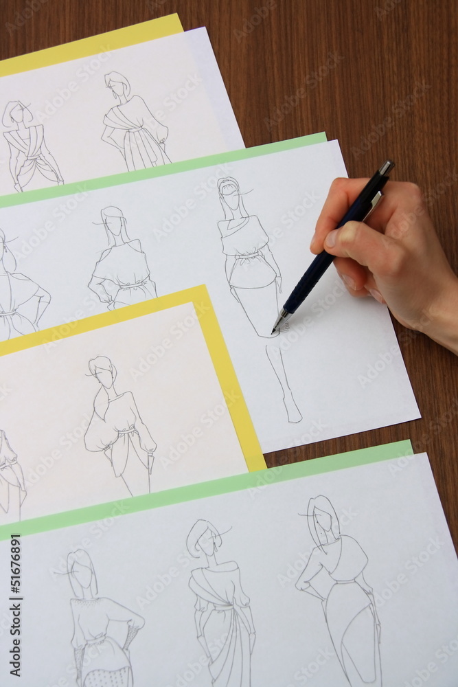 designer assessing fashion drawings designer assessing fashion drawings