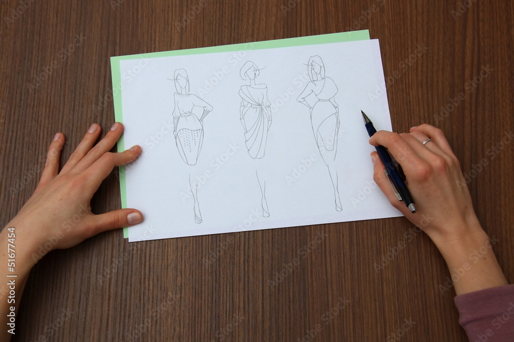 designer assessing fashion drawings designer assessing fashion drawings