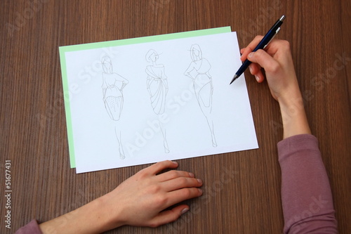 designer assessing fashion drawings