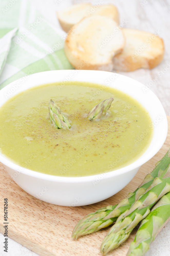 cream soup of asparagus and green peas in a bowl with toast cream soup of asparagus and green peas in a bowl with toast